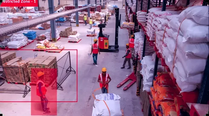 Warehouse aisle with a restricted zone outlined in red and a worker detected inside it