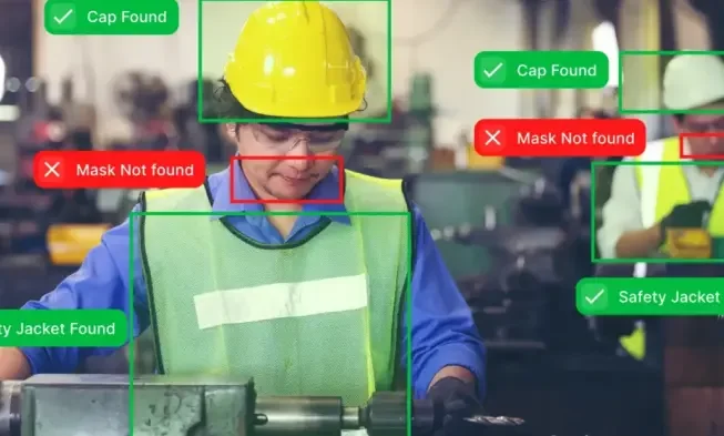 Worker at a machine with AI labels marking cap found, mask not found and safety jacket found