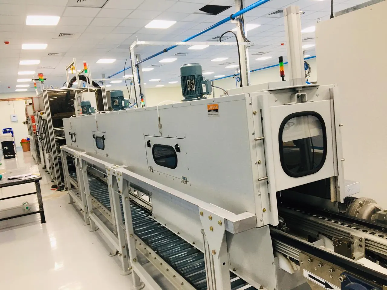 Entry end of an enclosed conveyor chamber with inspection windows
