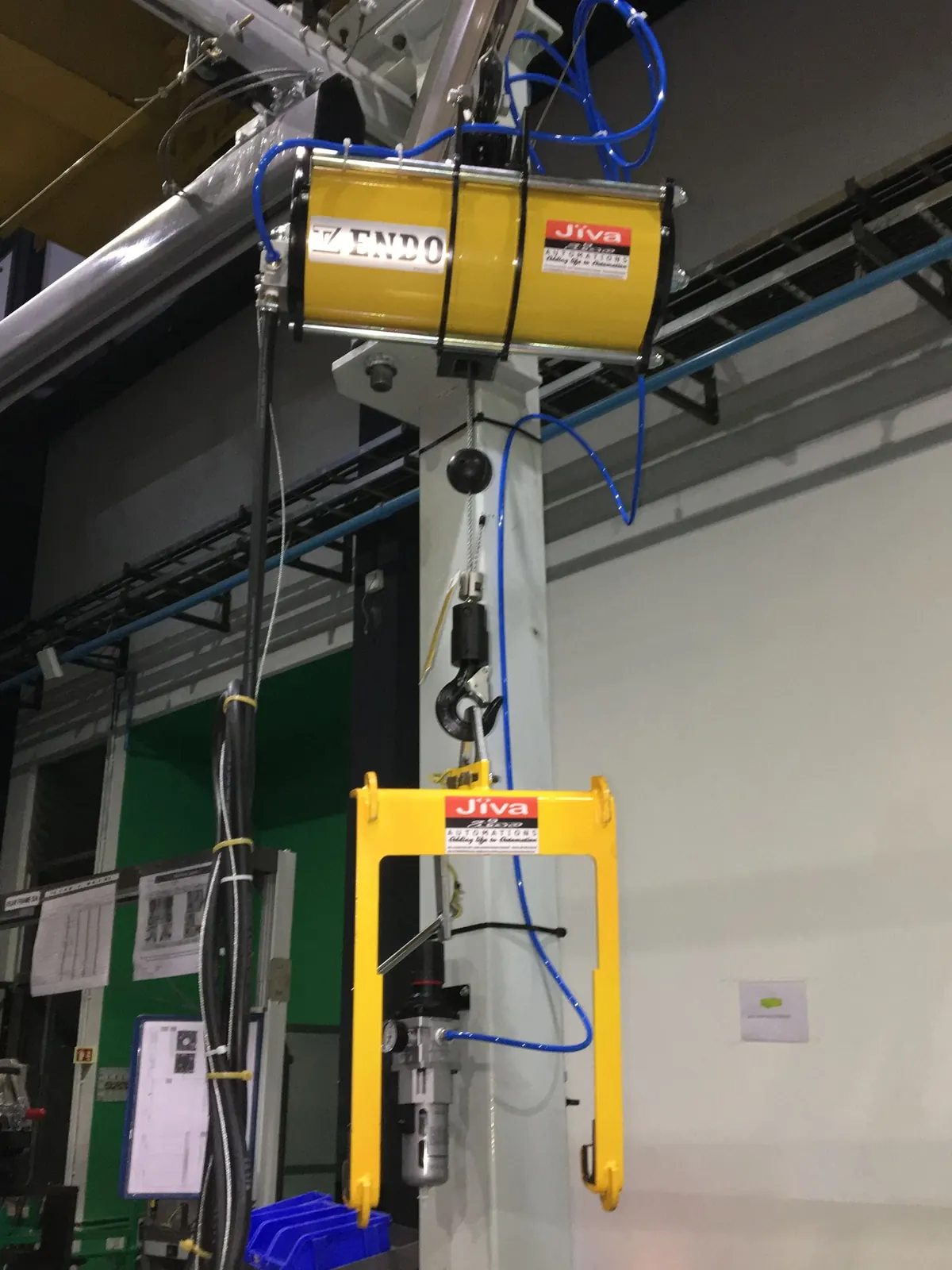 Yellow pneumatic balancer on a pillar with a JIVA lifting fixture