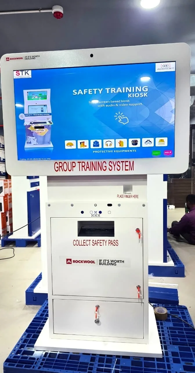 D-TECH Group Training System safety kiosk on the ROCKWOOL factory floor, showing the Safety Training Kiosk screen and a Collect Safety Pass slot