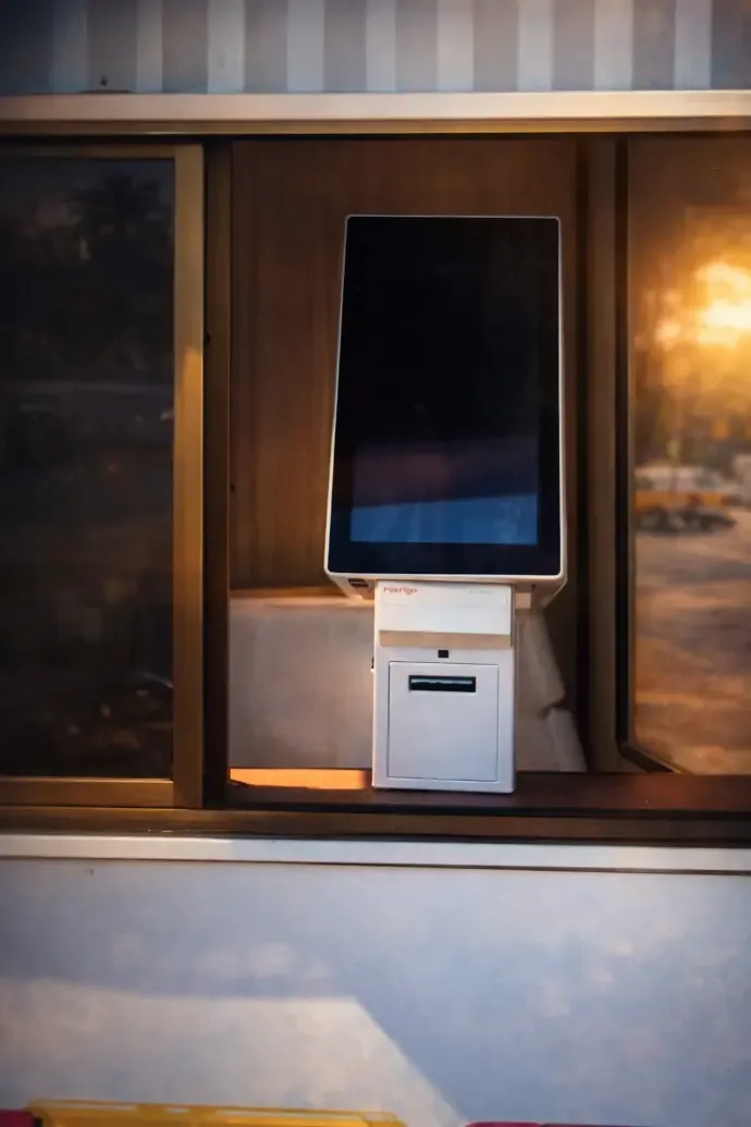 Touchscreen token kiosk with a ticket printer mounted inside a cabin window