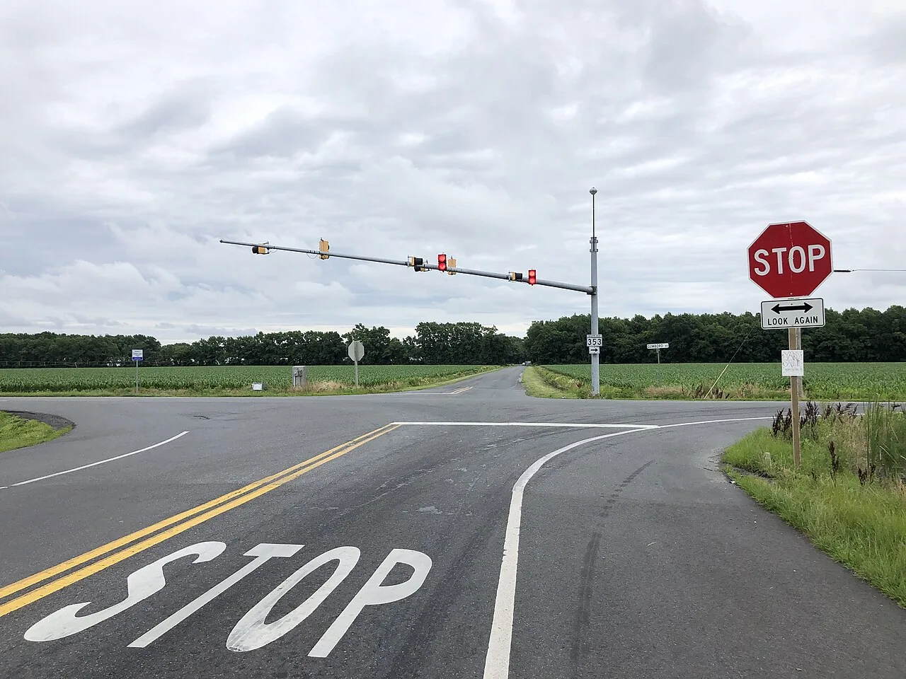 Road intersection with a painted STOP marking and stop sign